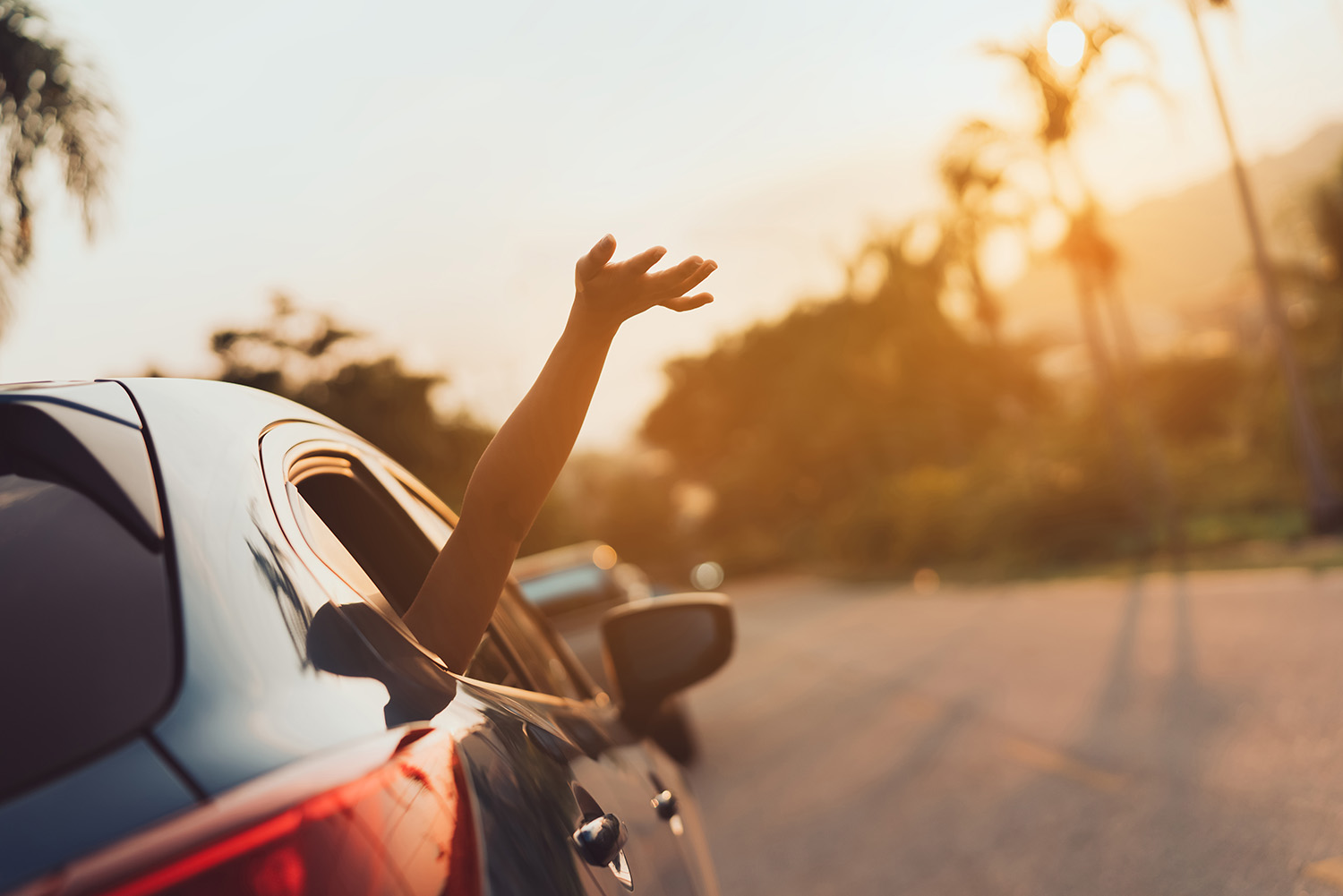 Girl with hand out window on summer drive