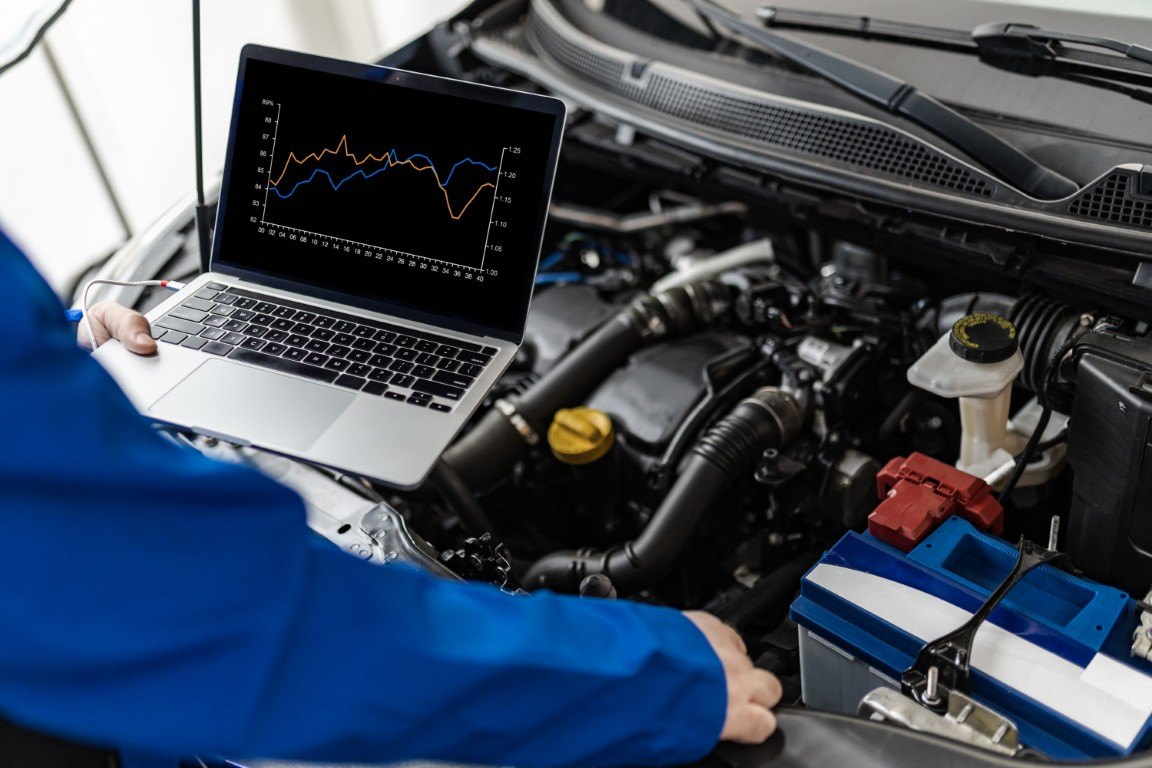 Laptop showing live engine data connected to a vehicle during diagnosis