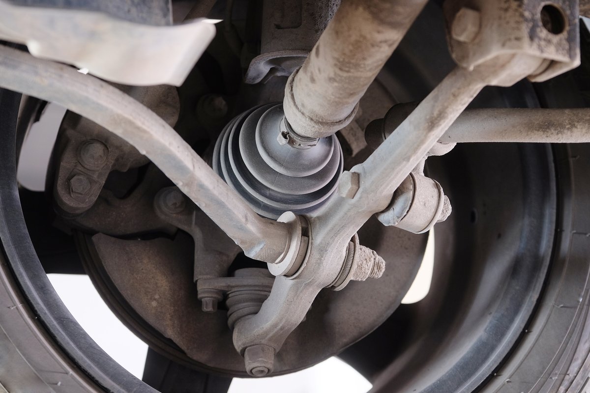 CV axle and its protective rubber boot visible behind a vehicle wheel