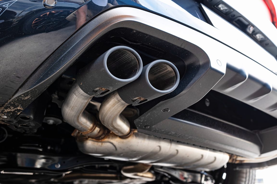 Dual chrome exhaust tips below the rear bumper of a car