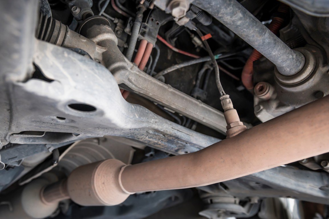 Exhaust pipes and heat shielding seen from underneath a vehicle