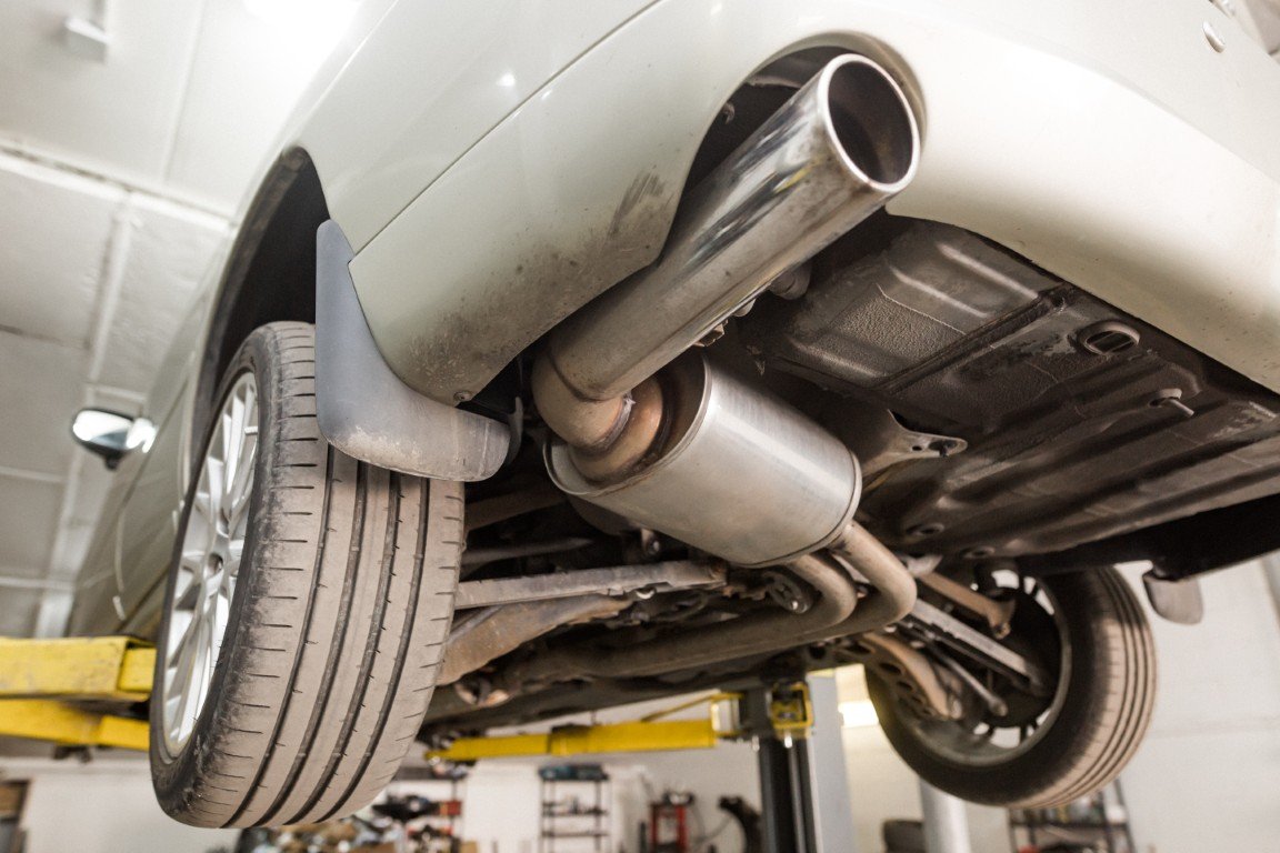 Vehicle raised on a shop lift with its exhaust system ready for service