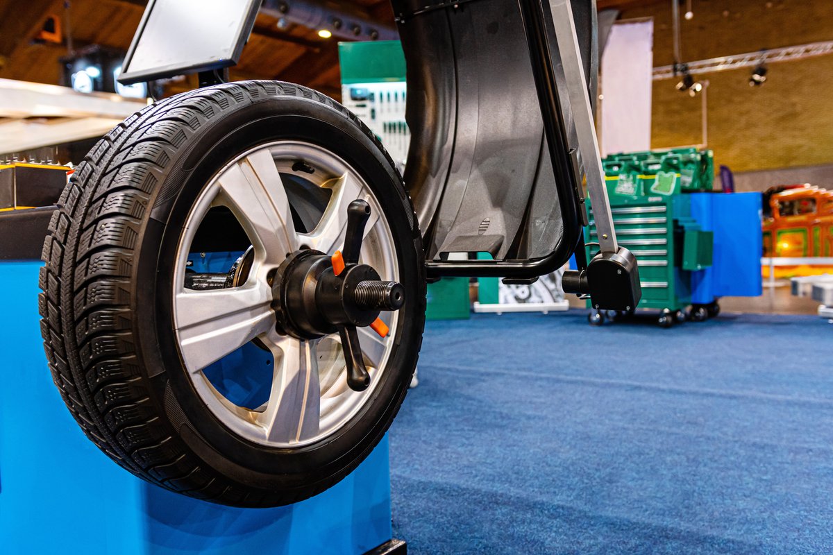 Wheel and tire mounted on a balancing machine in an auto repair shop