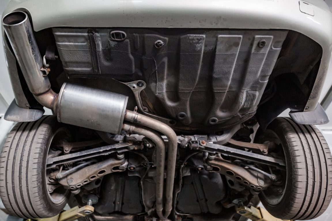 Muffler and mid-pipe seen from underneath a vehicle